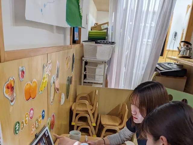 タブレットで打ち合わせる職員（なのは乳児園）